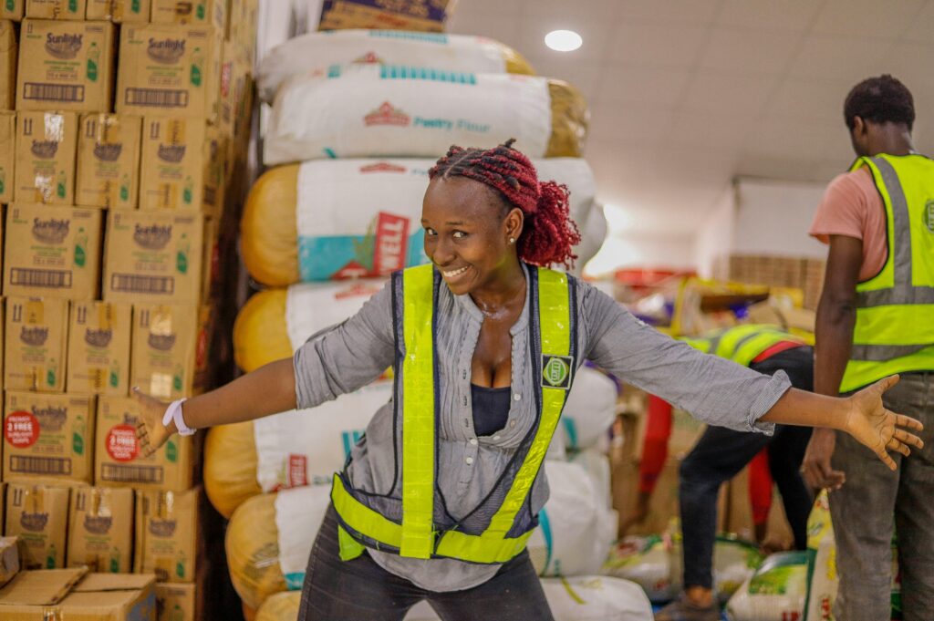 An African professional standing in front of Agricultural produce. The image highlights the joy that comes from efficient expense management in Africa and the need for financial control, budgeting, and strategic growth.