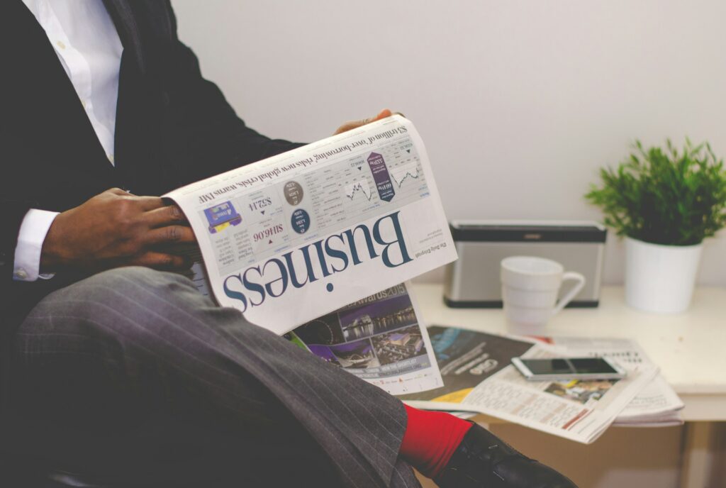 An African professional reading a business focused newspaper. The image highlights dedication that is necessary to implement efficient spend management in Africa and the need for financial control, budgeting, and strategic growth.